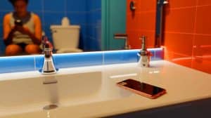 Illustration of the health risks associated with using smartphones in the bathroom.